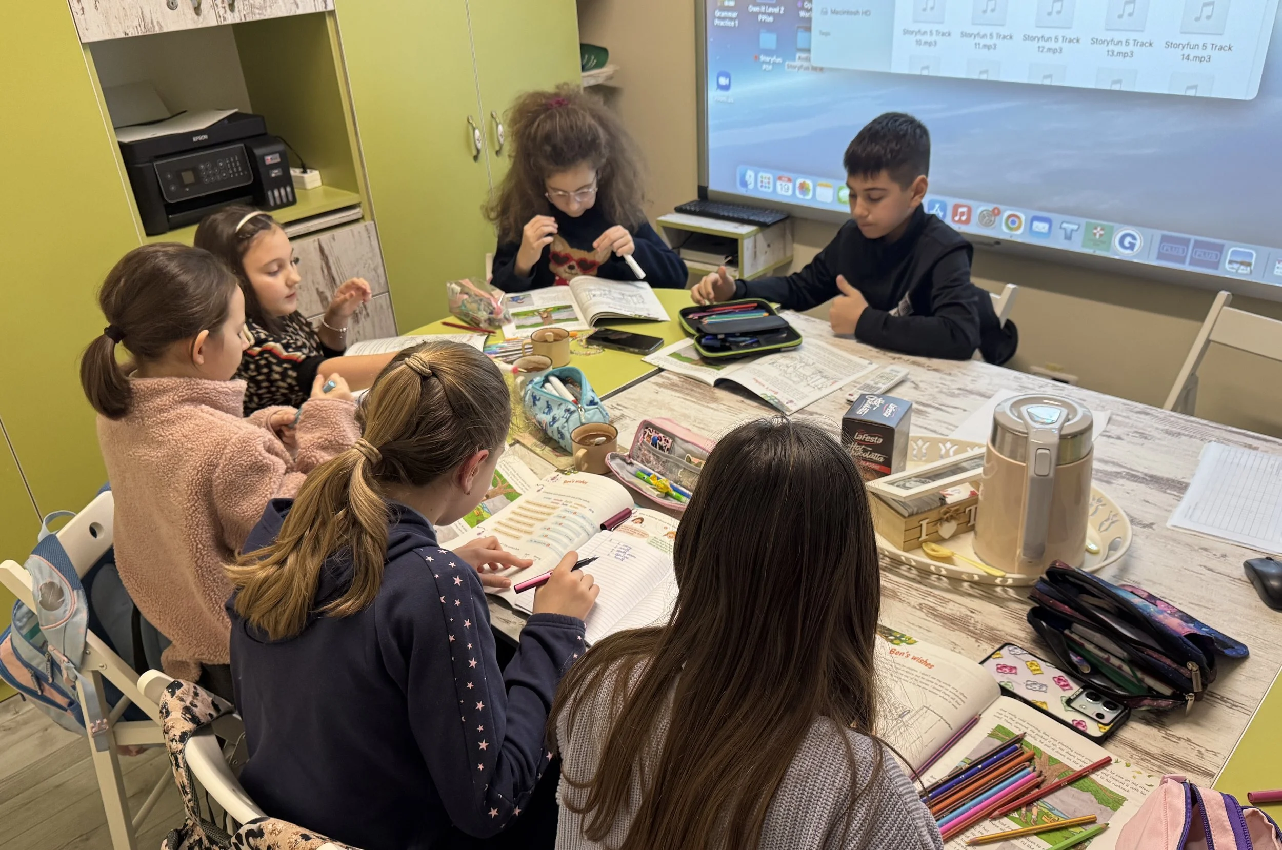 Copii la York Rose Language School din Constanța participând la o lecție interactivă de limba engleză, lucrând pe reviste educaționale și fișe de lucru într-o atmosferă relaxată,