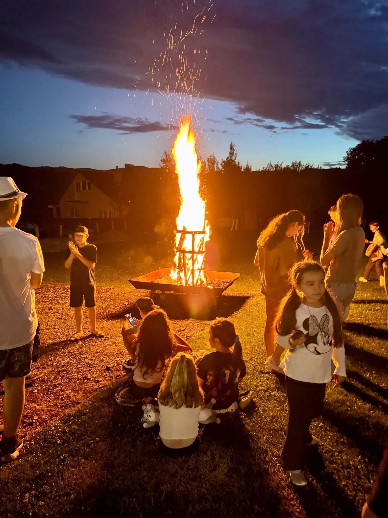 Copii la foc de tabără în tabăra de limba engleză York Rose – activități de seară și socializare în aer liber.