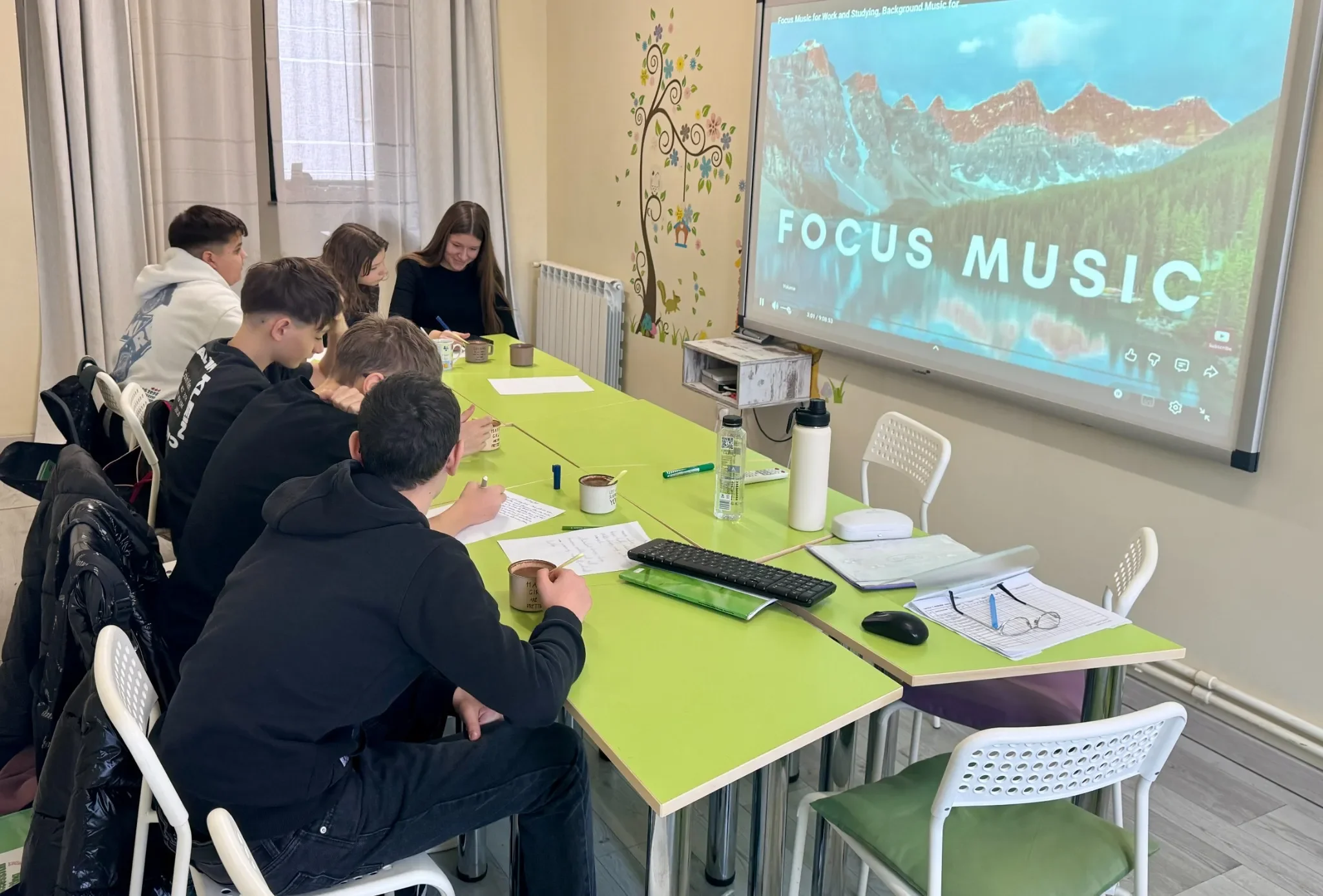 Adolescenți la curs de limba engleză și pregătire Cambridge la York Rose Constanța, lecție interactivă cu suport digital și exerciții scrise.