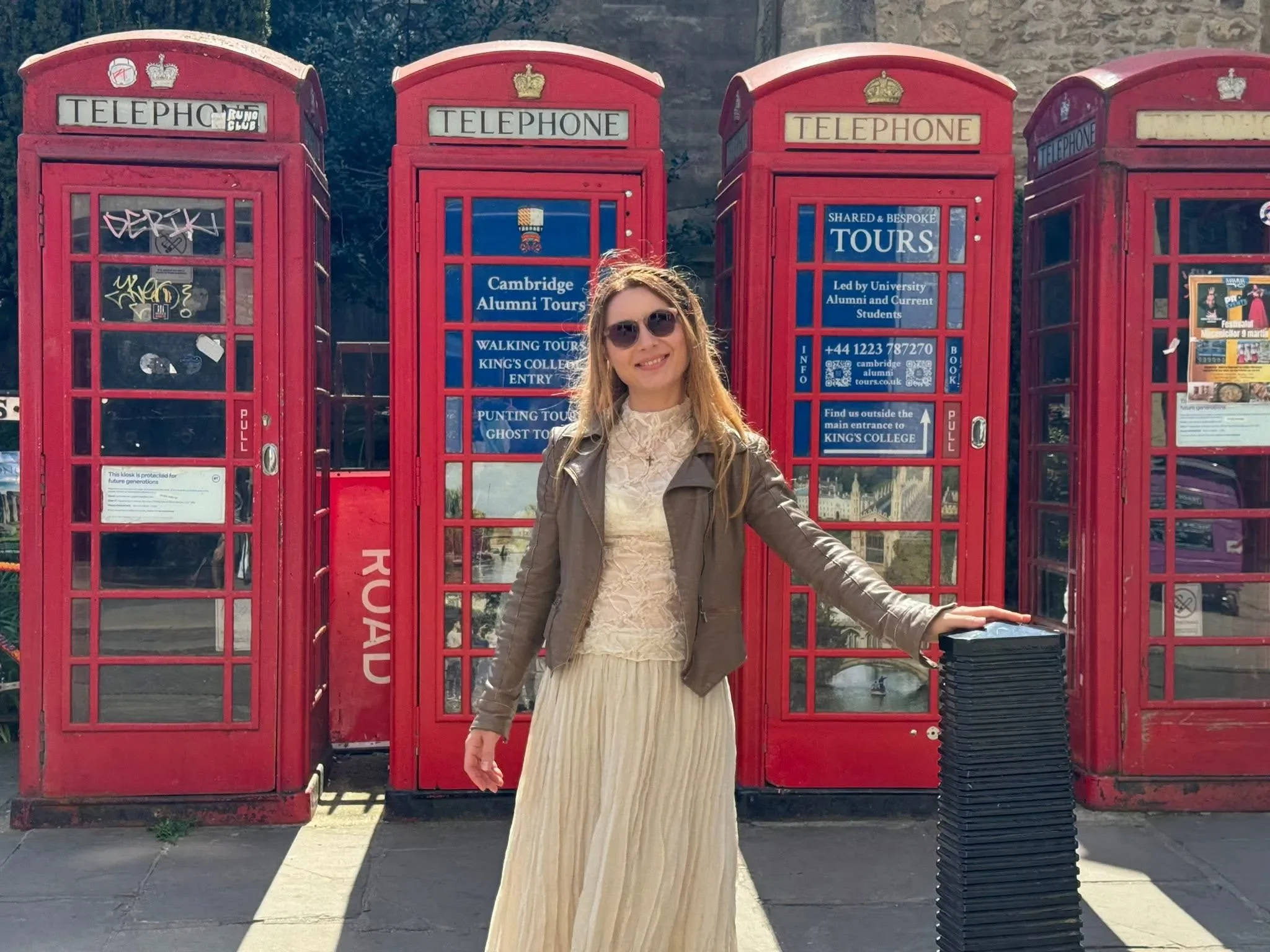Profesoara fondatoare a centrului lingvistic York Rose, zâmbind în fața unor cabine telefonice roșii tradiționale din Londra.