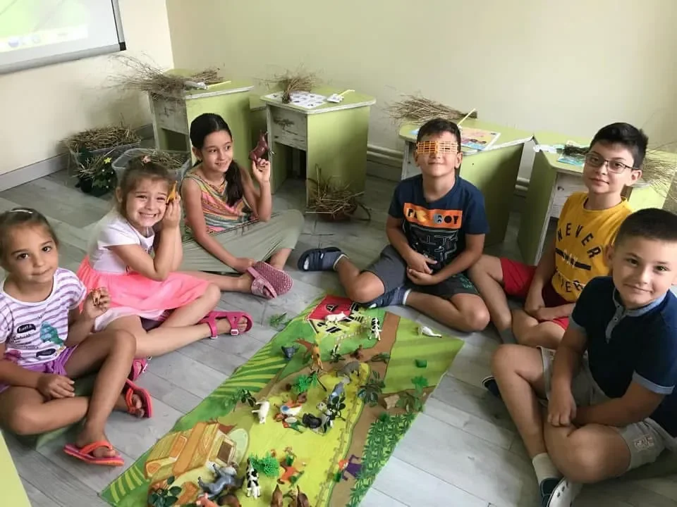 Copii participă la activitate educativă prin joc cu figurine și scenarii tematice în cadrul cursurilor de limbi străine la York Rose Constanța