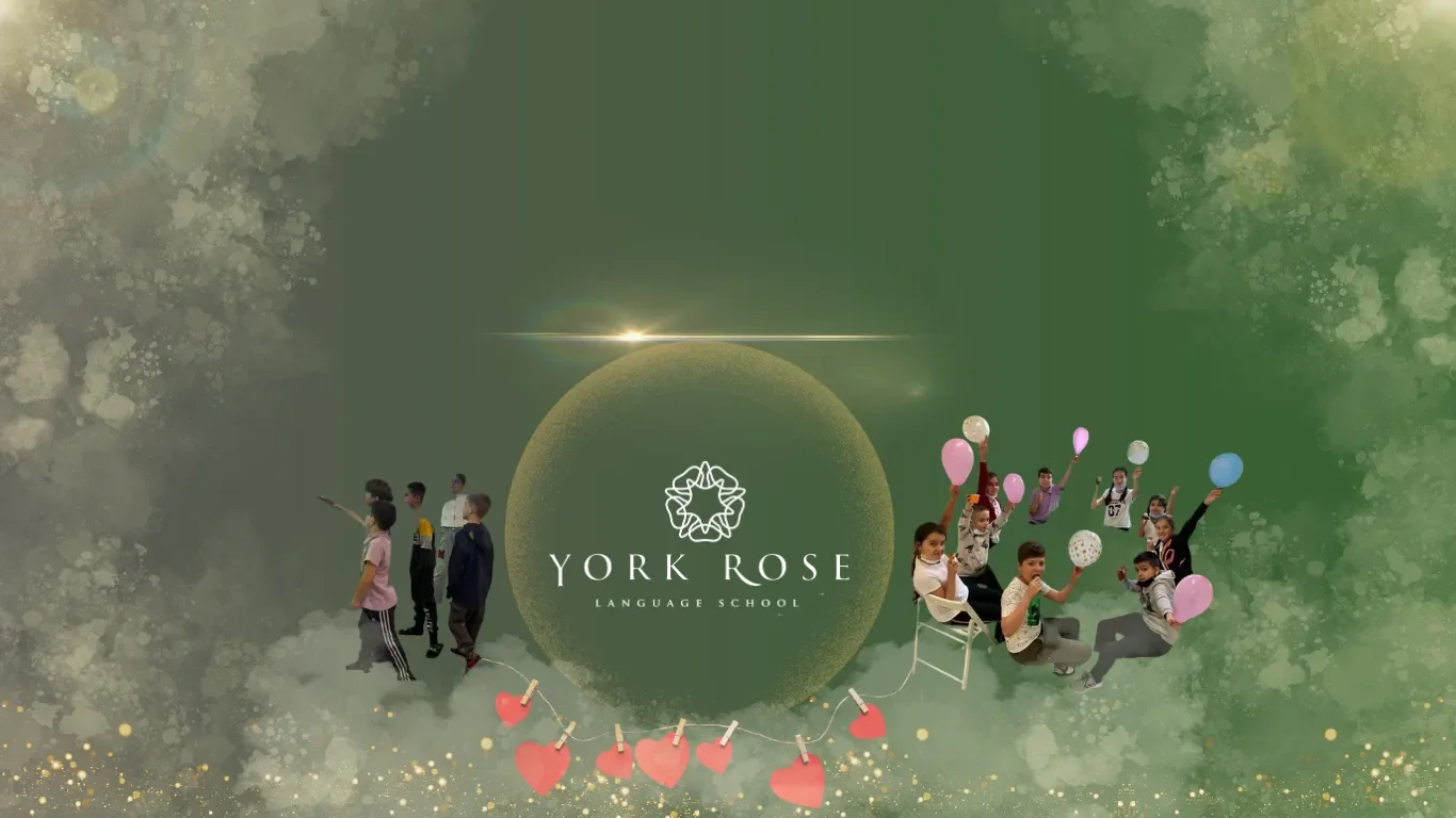 Bannerul secțiunii de englezǎ vara Jolly Hearts la York Rose in Constanța pe fundal verde, înfățișând copii veseli care țin baloane colorate, o ghirlandă cu inimi roz din hârtie și logo-ul școlii încadrat central într-un cerc auriu.