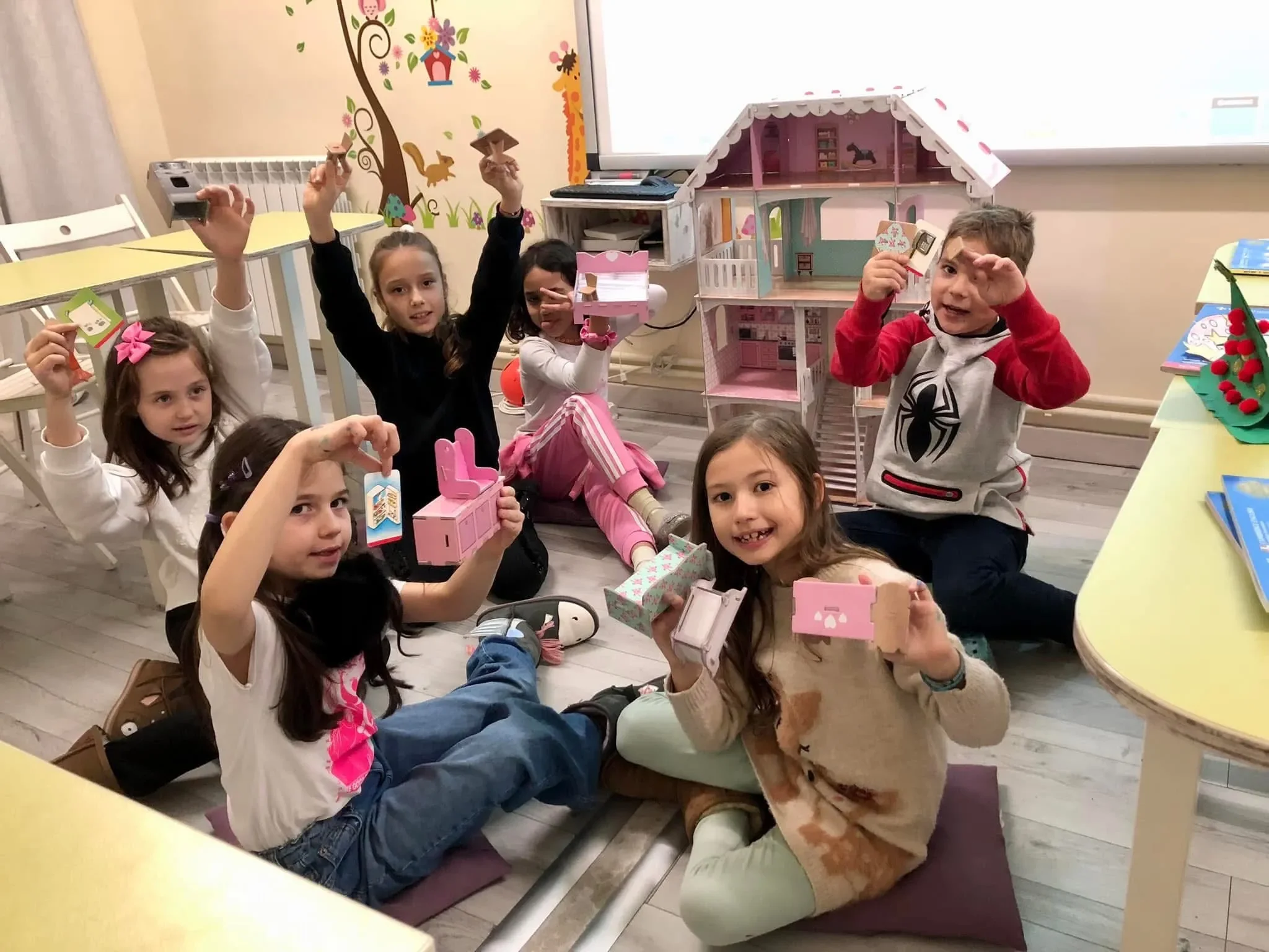 Copii învățând prin joacă la cursuri de limbi străine, prezentând creații handmade într-o clasă modernă la York Rose Constanța