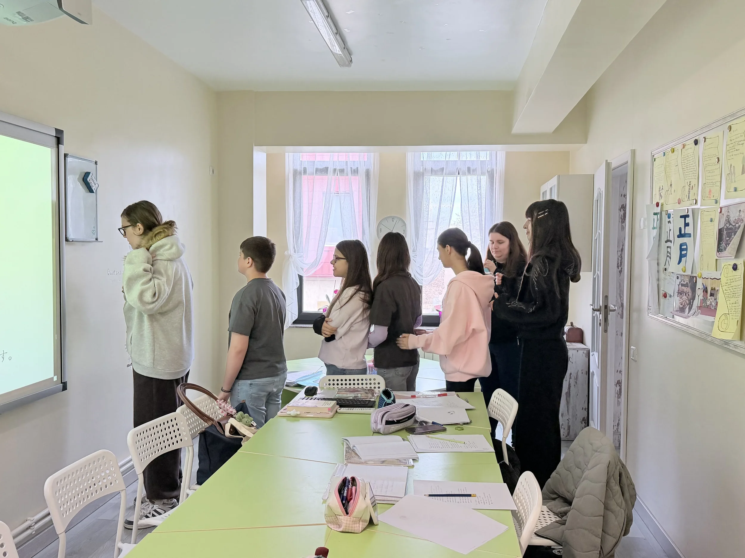Elevi de peste 10 ani aliniați în fața unui ecran digital interactiv în timpul unui atelier recreativ de limba japoneză în Constanța. Învățare modernă, experiențială și dinamică de grup la York Rose.