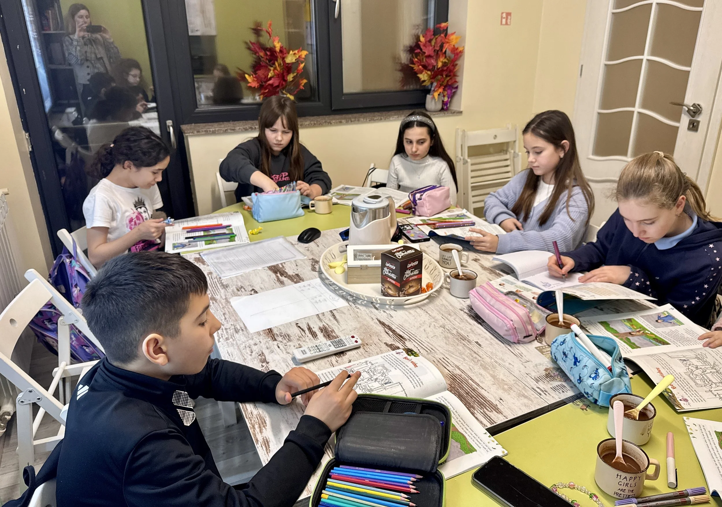 Elevi la York Rose Language School din Constanța participând la o lecție de limba germană, lucrând individual pe manuale și fișe de lucru într-un cadru educațional interactiv.