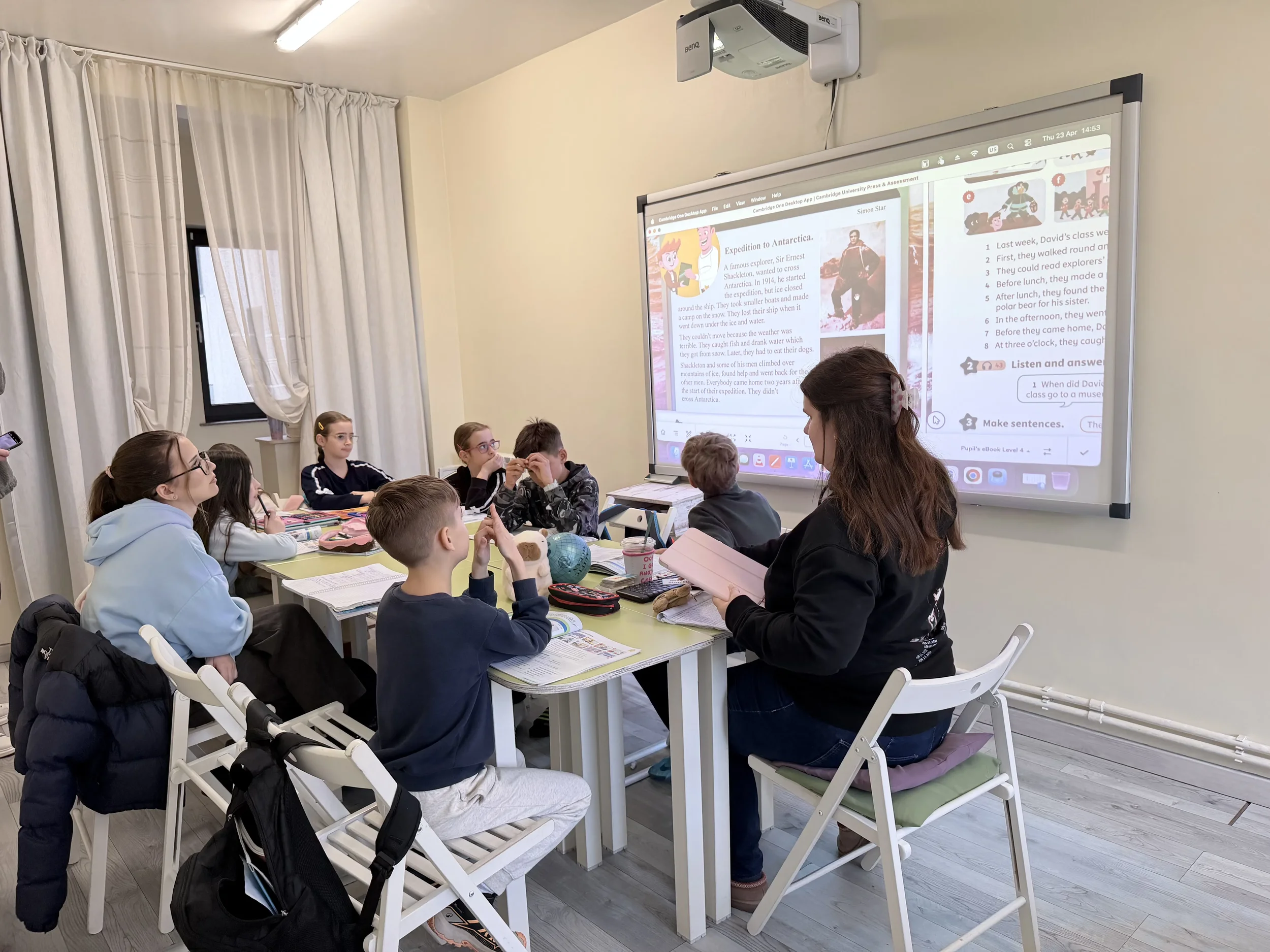 Copii atenți la o lecție de engleza interactivă despre Antarctica proiectată pe ecran digital la York Rose din Constanta