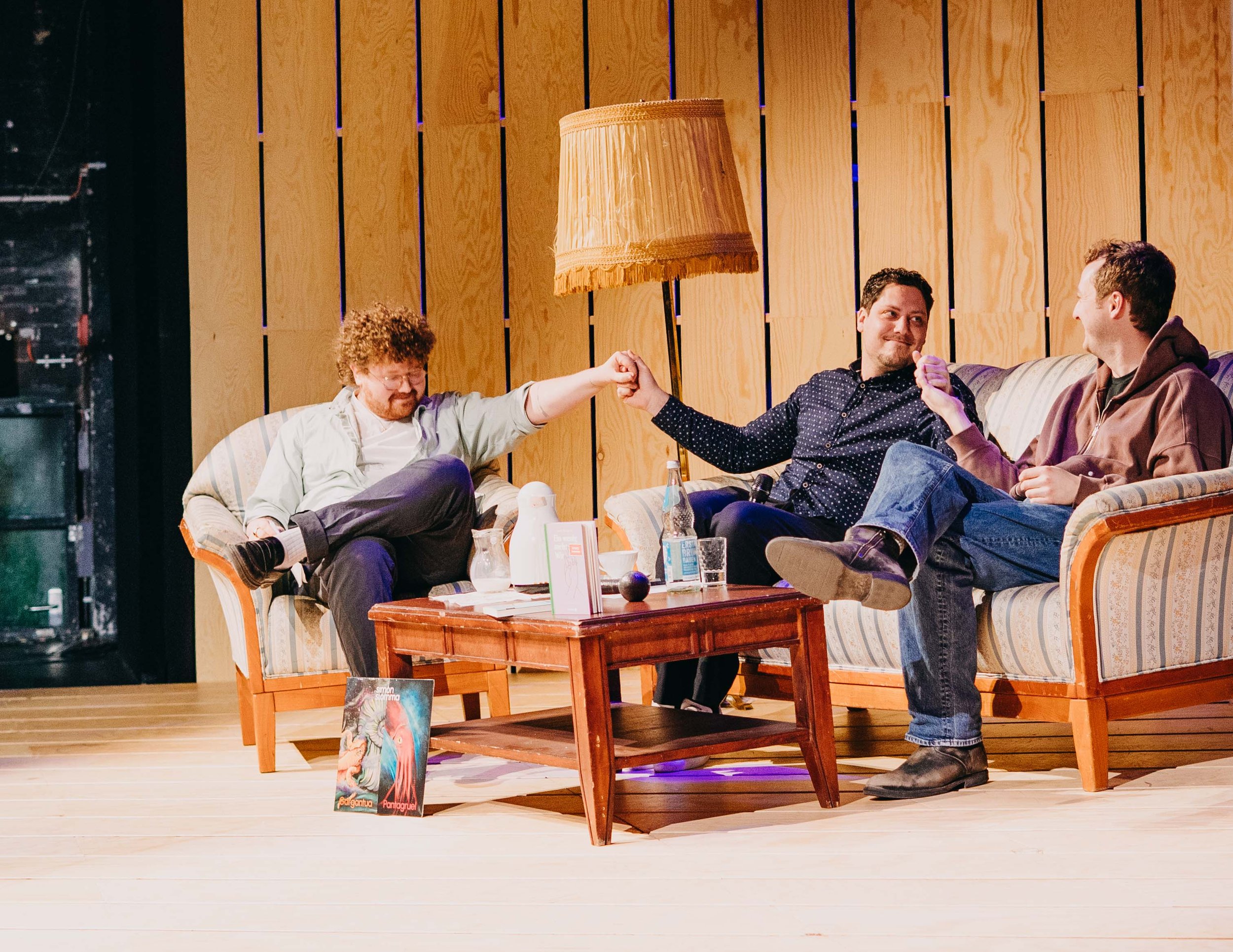 Kolja Fach, David Friedrich und Phillipp Potthast sitzen auf einer Couch auf der Bühne des Ernst Deutsch Theaters in Hamburg.