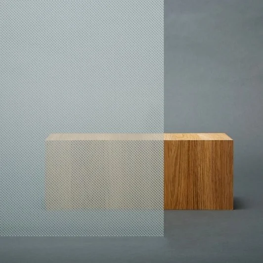 En stor gjenstand delt i to, med en halv del av metall og den andre av tre, plassert på en grå overflate.