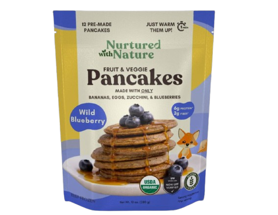 Package of Nurtured with Nature fruit and veggie pancakes with blueberries, showing a stack of pancakes topped with blueberries and a small cartoon fox, with labels indicating organic, protein, fiber, and USDA certification.