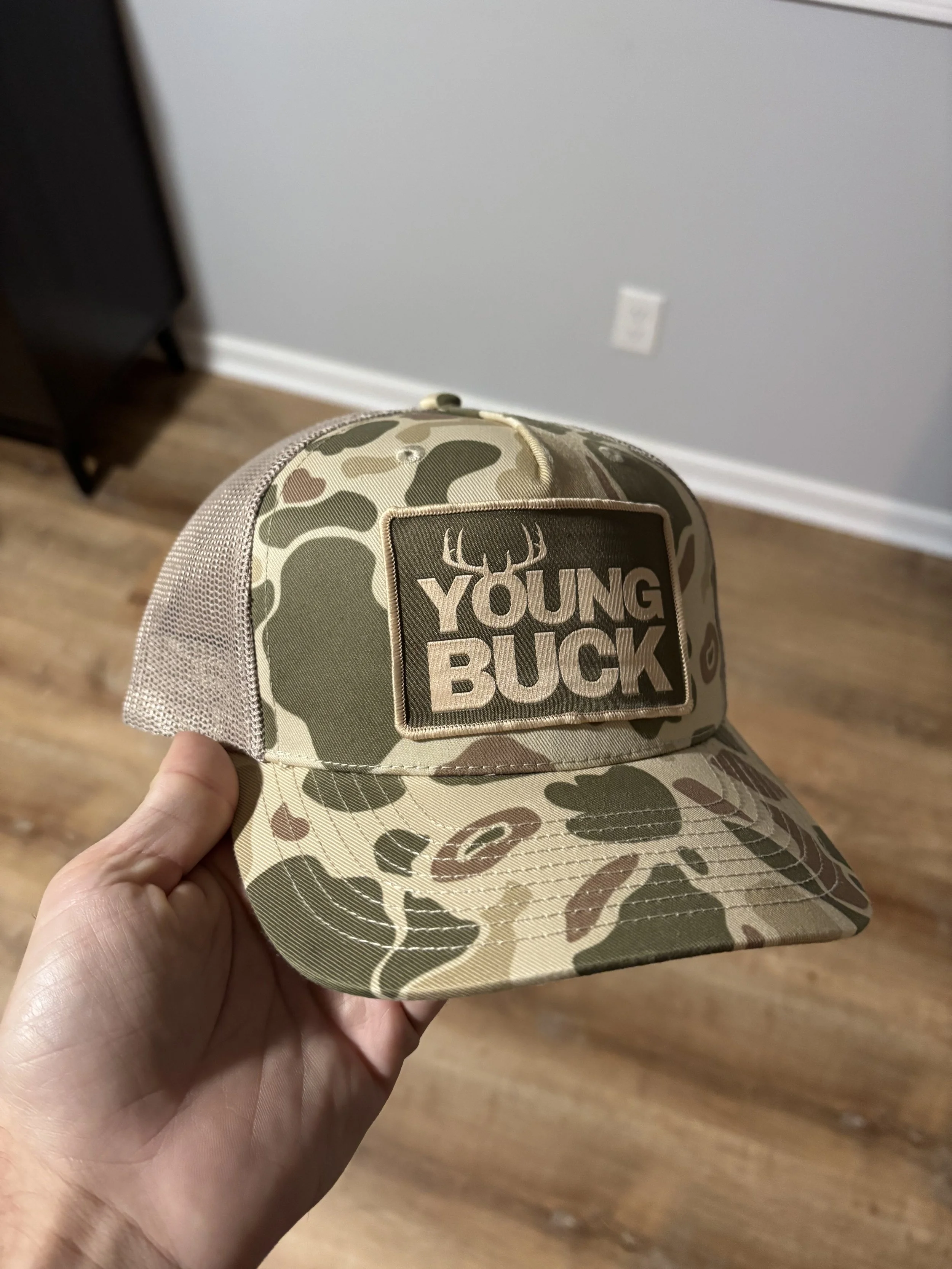 Custom camouflage trucker hat with Young Buck logo patch branding design