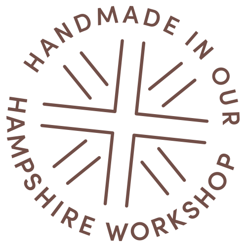 Circular logo with the text 'Handmade in our Hampshire Workshop' surrounding a stylized cross design.