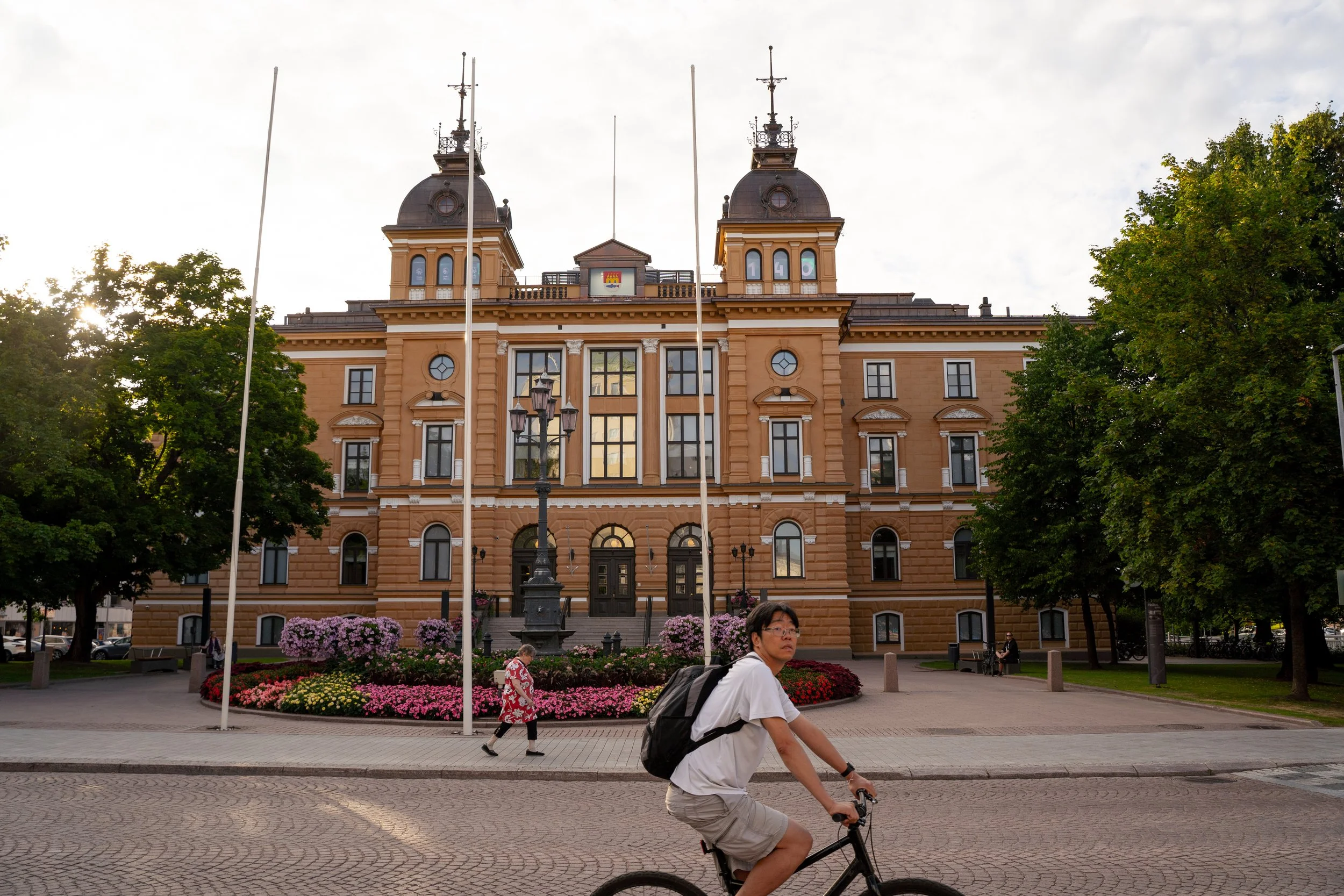 Pyöräilijä Oulun kaupungintalon edessä kesällä 2025