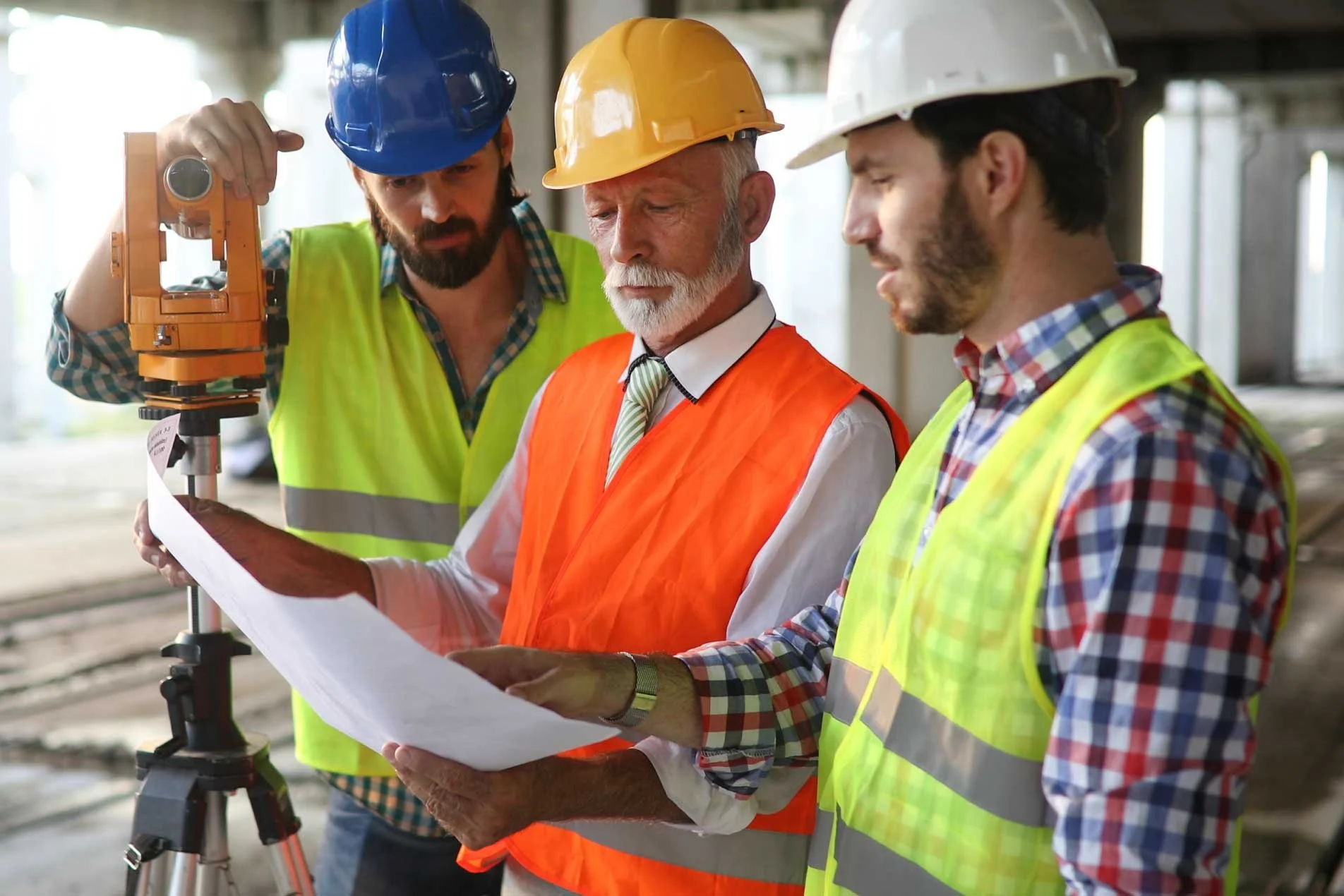 Site manager speaking with two employees on a construction site.