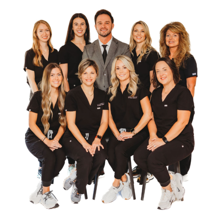 Group of nine people, mostly women, in professional athletic attire, posing for a photo against a plain white background.