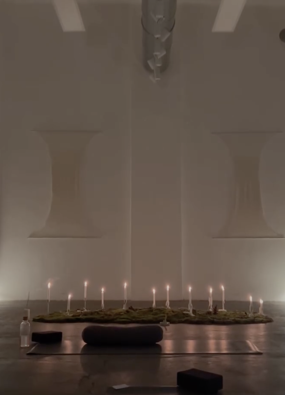 Candles arranged for a meditation session in a softly lit wellness space in Milan