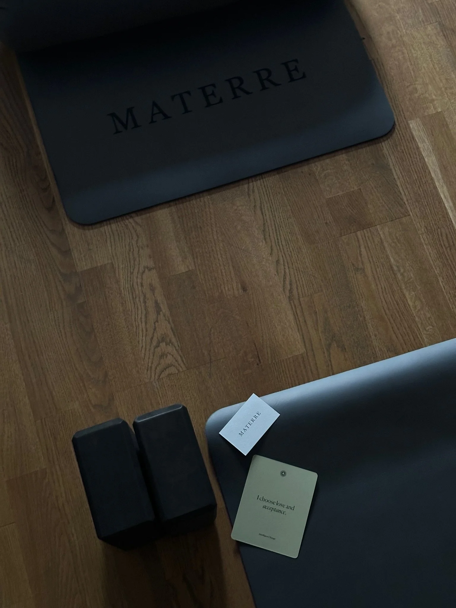 A seating area with black chairs, one with a white card that reads 'I choose love and acceptance,' and a small black card with the brand name 'MATTERE' on the black cushion.