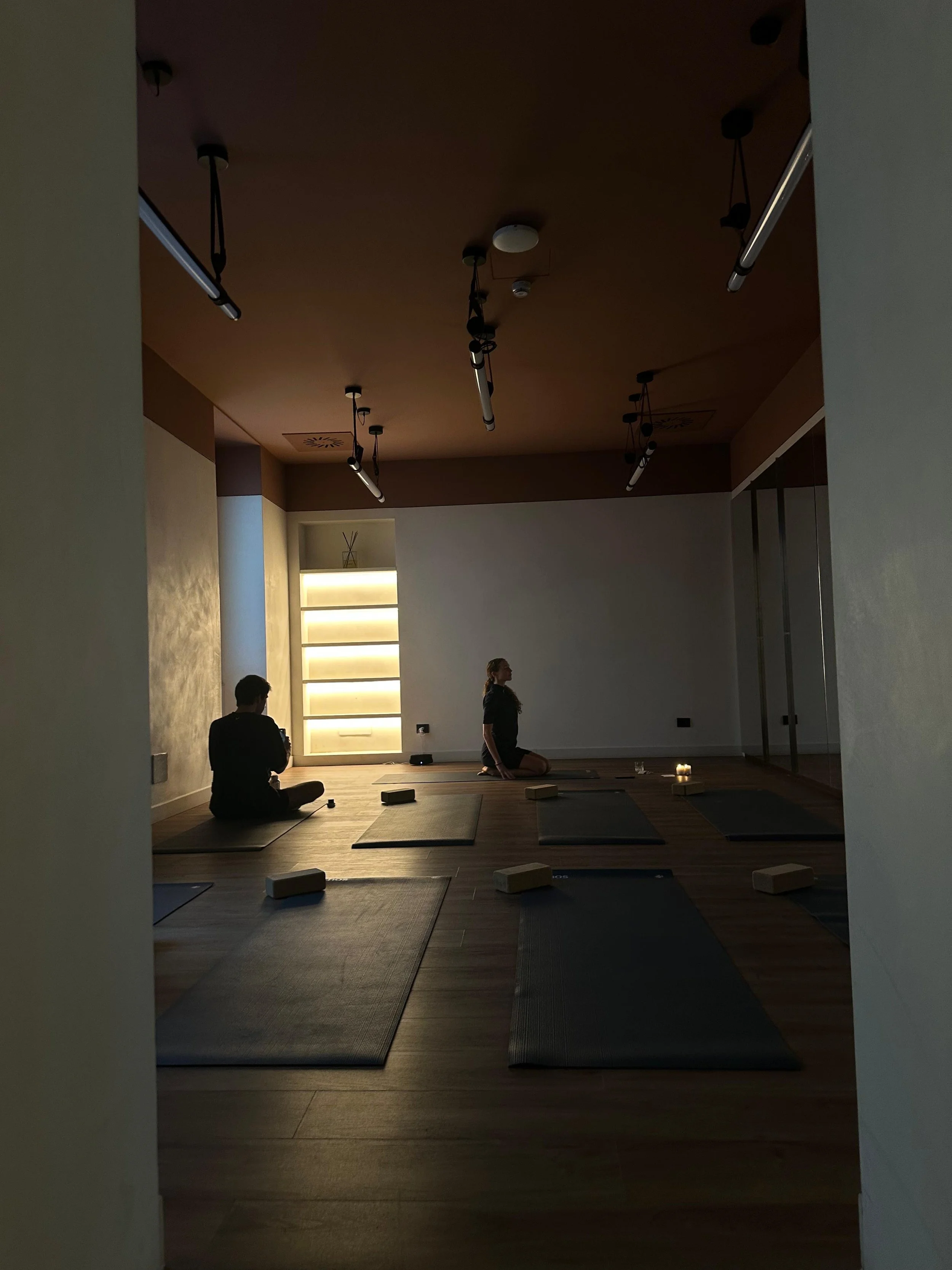 People seated on yoga mats during an evening movement class