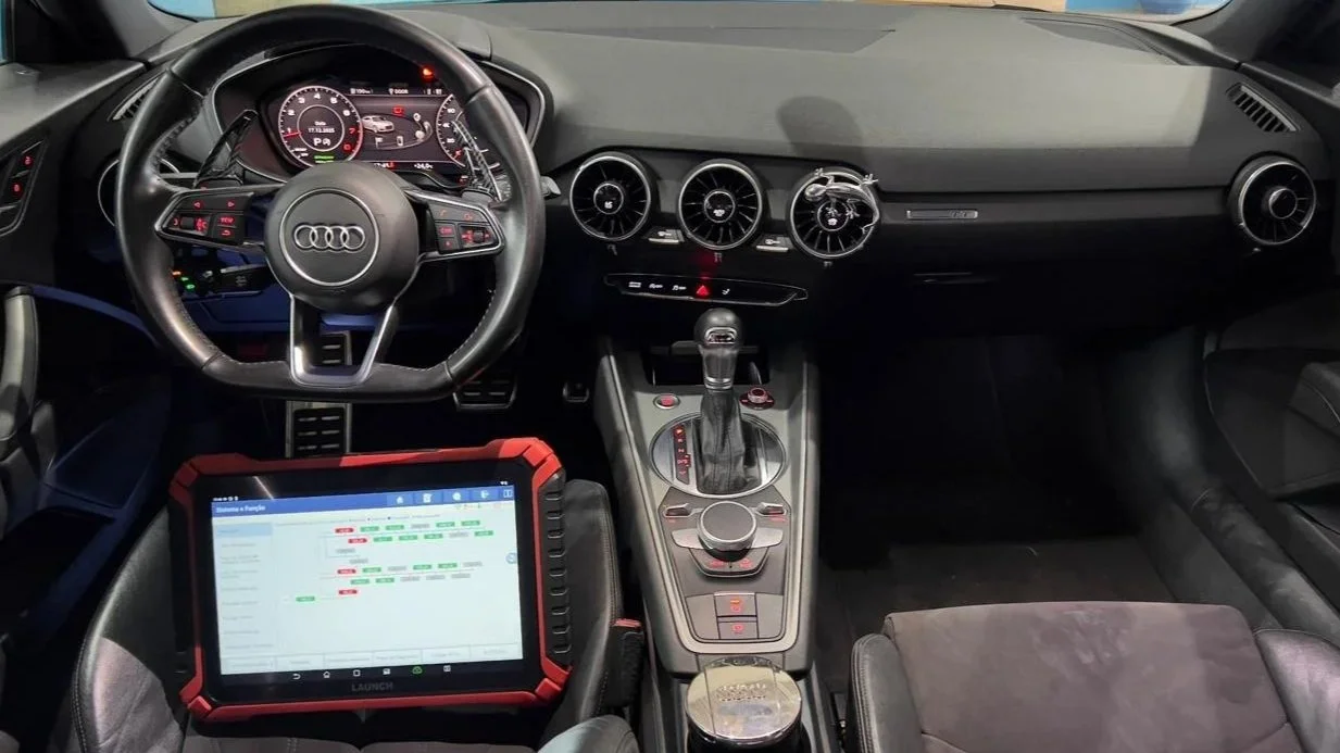 Interior de carro de alta performance, com volante, painel digital, central de comando enjoada e tablet com software de análise de dados.