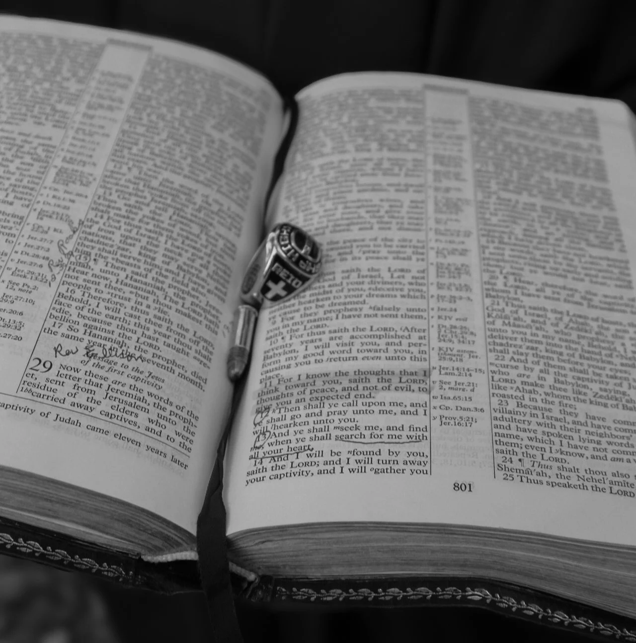 An open Bible with a black ribbon bookmark and a Swiss Army knife placed on the pages.