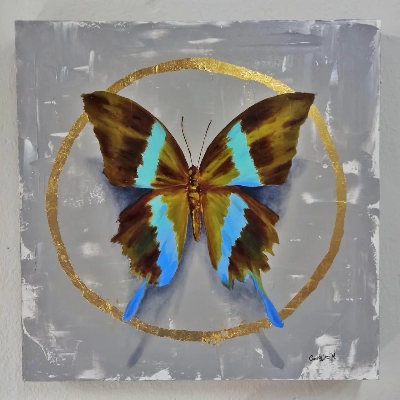 Ilustração de uma borboleta com asas amarelas, marrons e detalhes azuis, cercada por um círculo dourado, sobre fundo cinza com textura