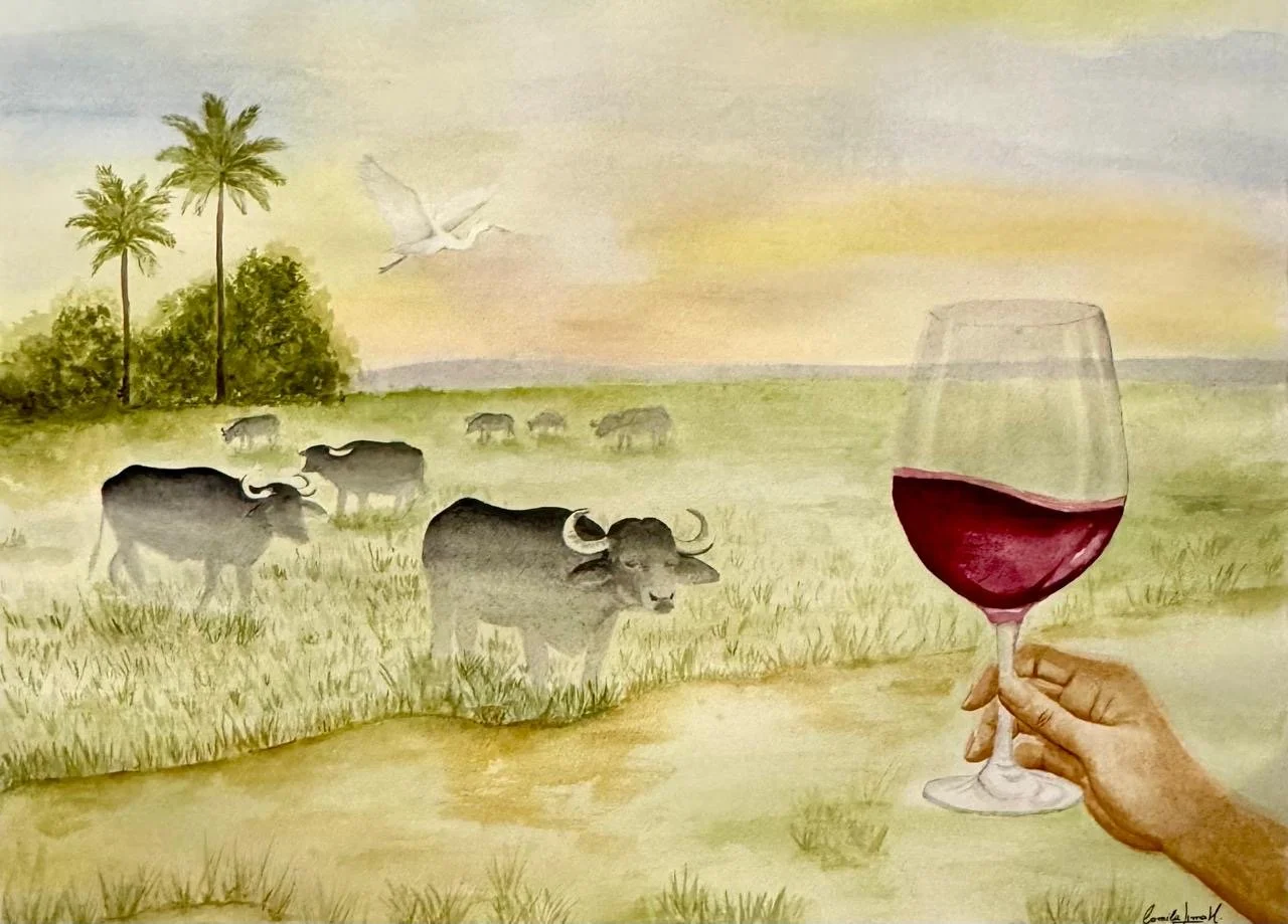 Pintura de uma paisagem com vacas pastando em um campo, duas perforas ao fundo, uma árvore e uma ave voando, com uma mão segurando uma taça de vinho tinto na frente.