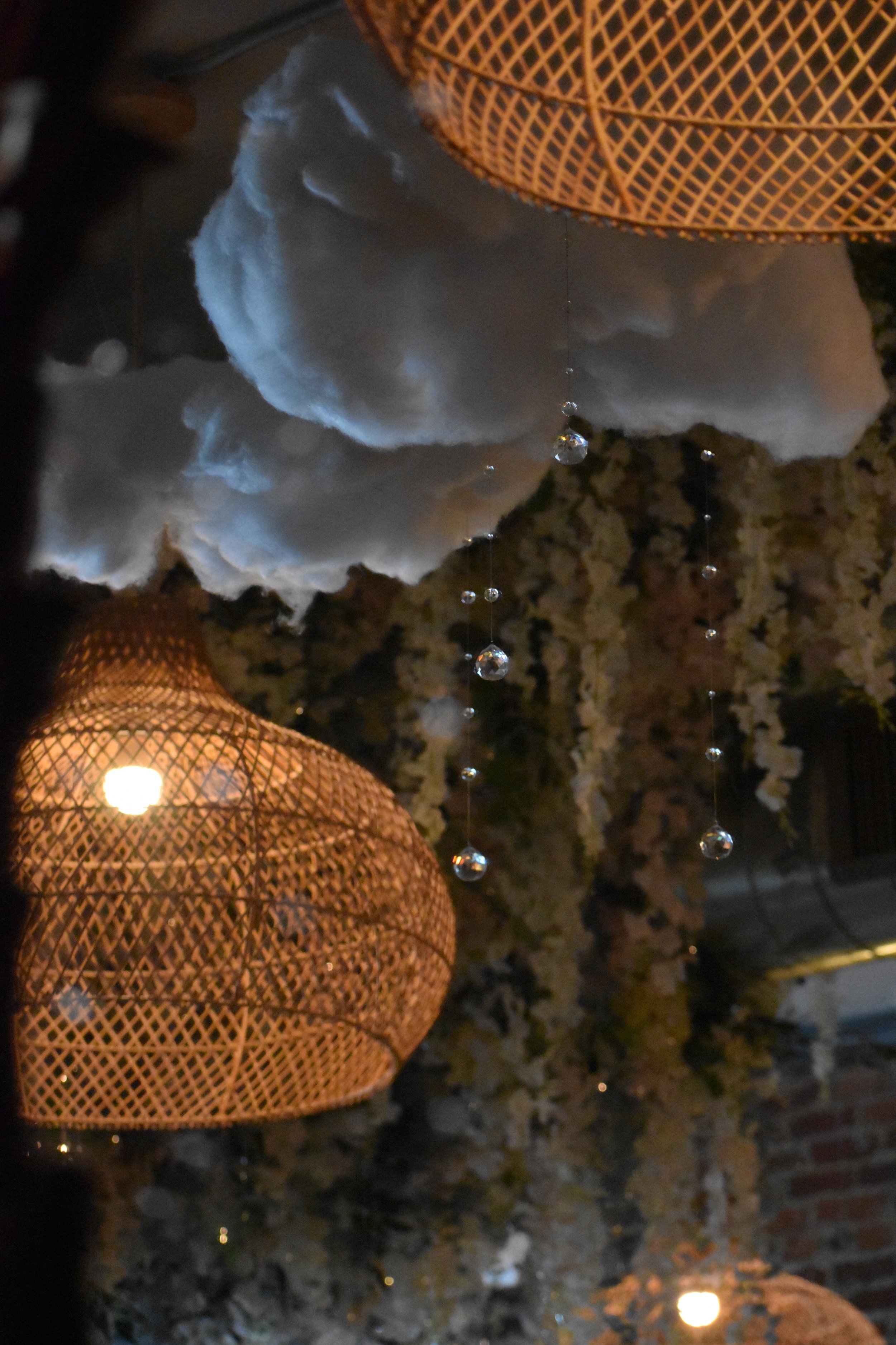 Decorative ceiling with hanging cotton clouds, woven rattan light fixtures, and crystal beads. Hamp & Harry's Marietta Square.