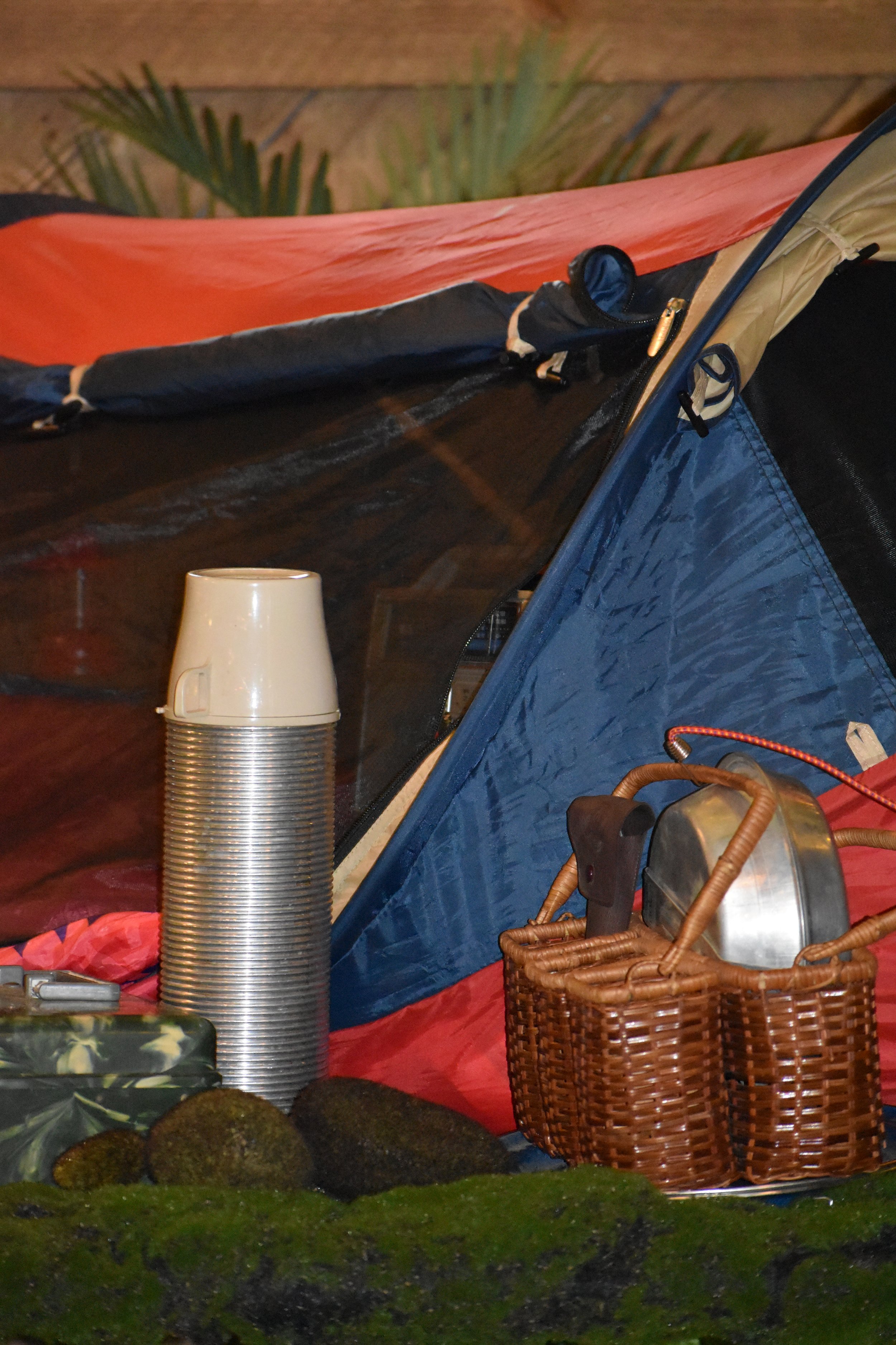 Camping tent with a plastic cup, wicker baskets, and rocks in front. Hamp & Harry's Marietta Square.