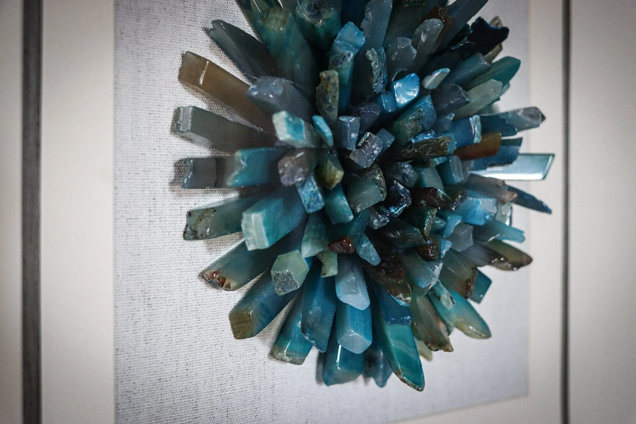 A large sculpture made of blue and green mineral crystals arranged in a circular, lotus flower-like pattern.