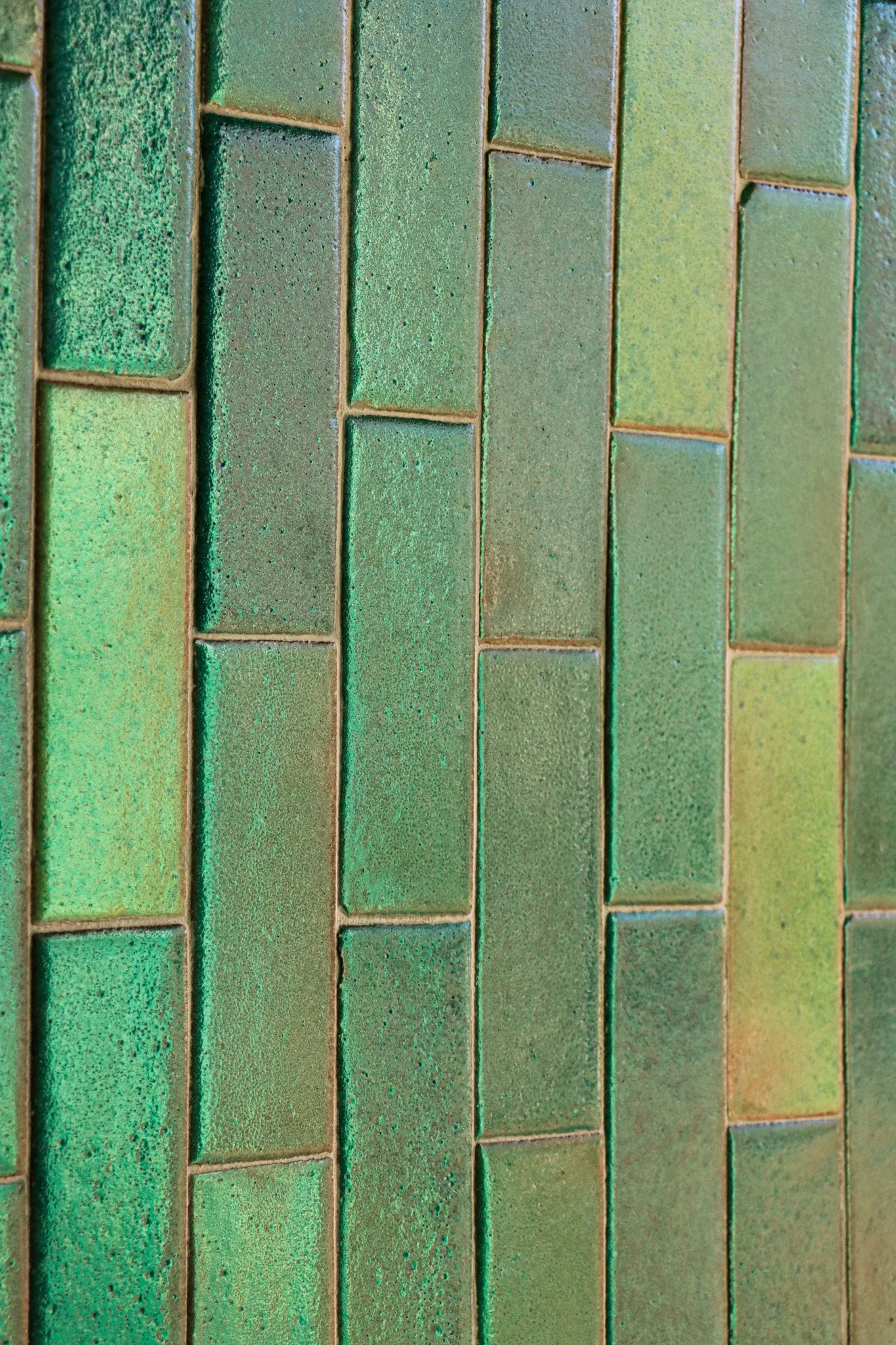 Close-up of green and yellow rectangular bricks arranged in a pattern.