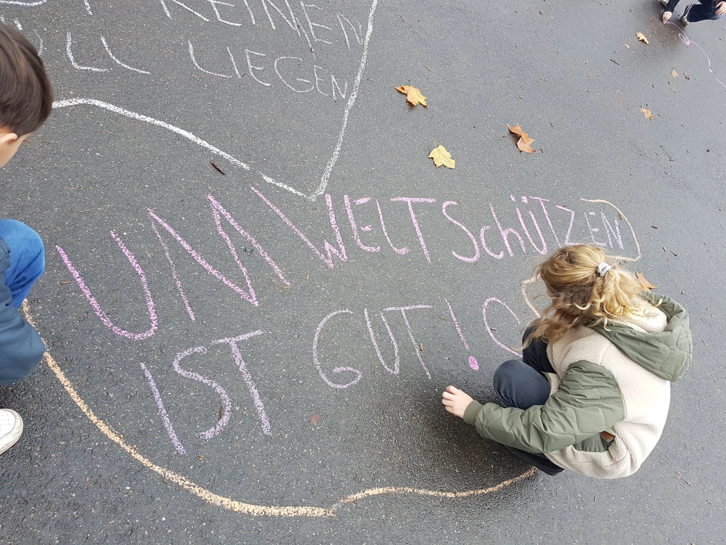 Eine Schülerin hinterlässt eine Nachricht für Ihre Mitschüler*innen auf dem Schulhof - Schuljahr der Nachhaltigkeit - WandelWerkstattWelt