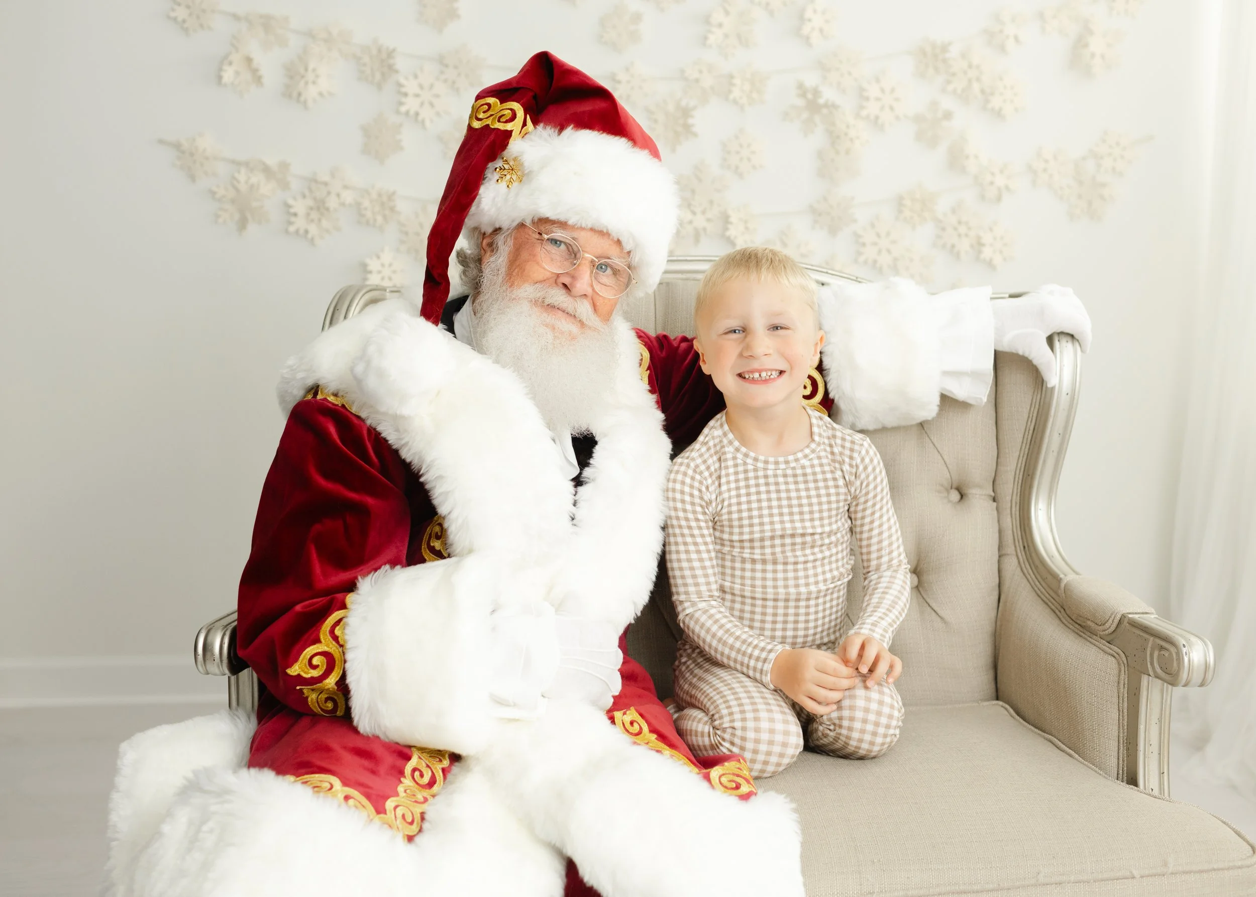 Smiling boy seated beside Santa Charlie in the Forest, Virginia studio