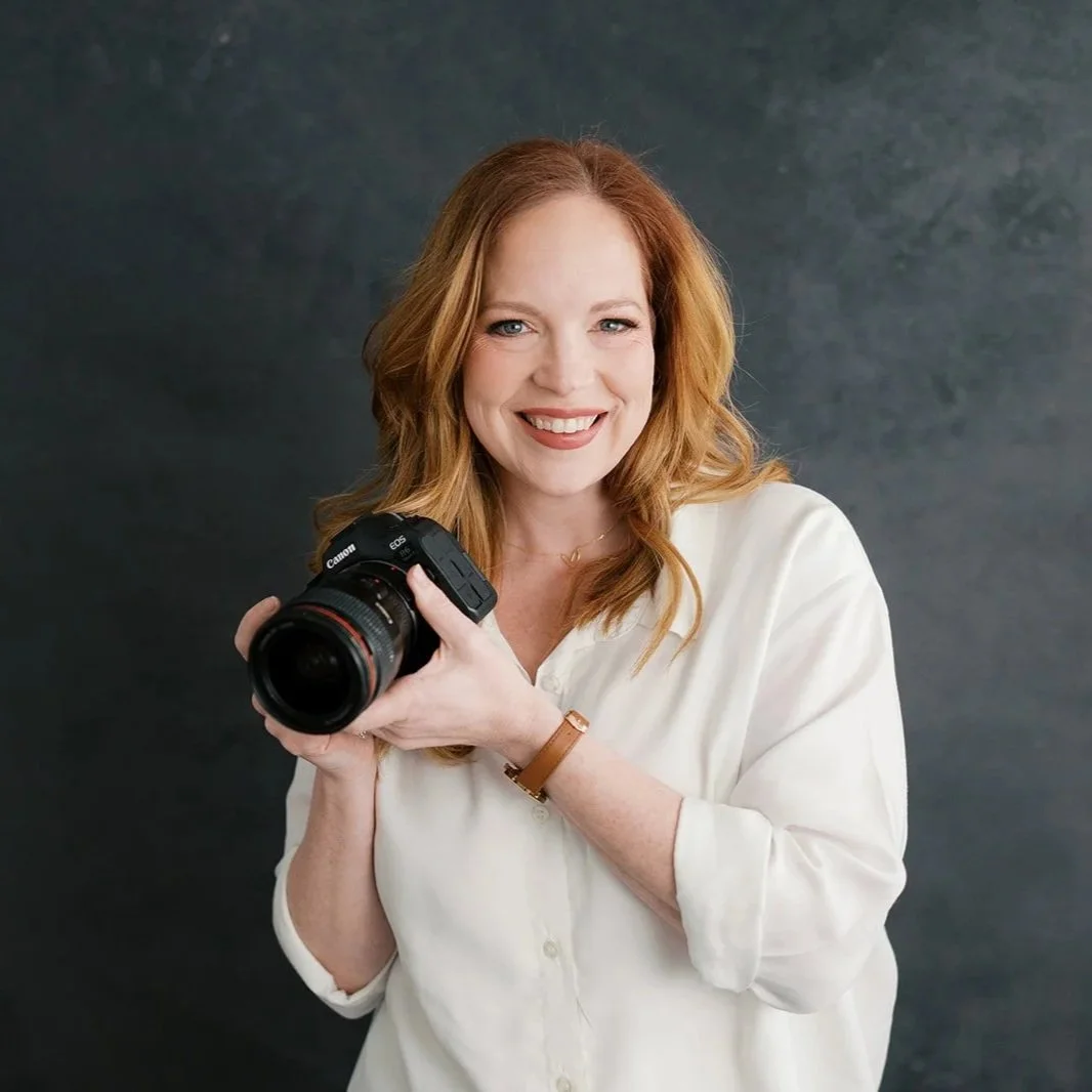 Liz Cook, Central Virginia family photographer holding a Canon camera against a dark studio backdrop