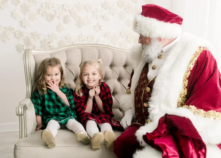 Two sisters smiling with Santa during a private Christmas session in Forest, Virginia
