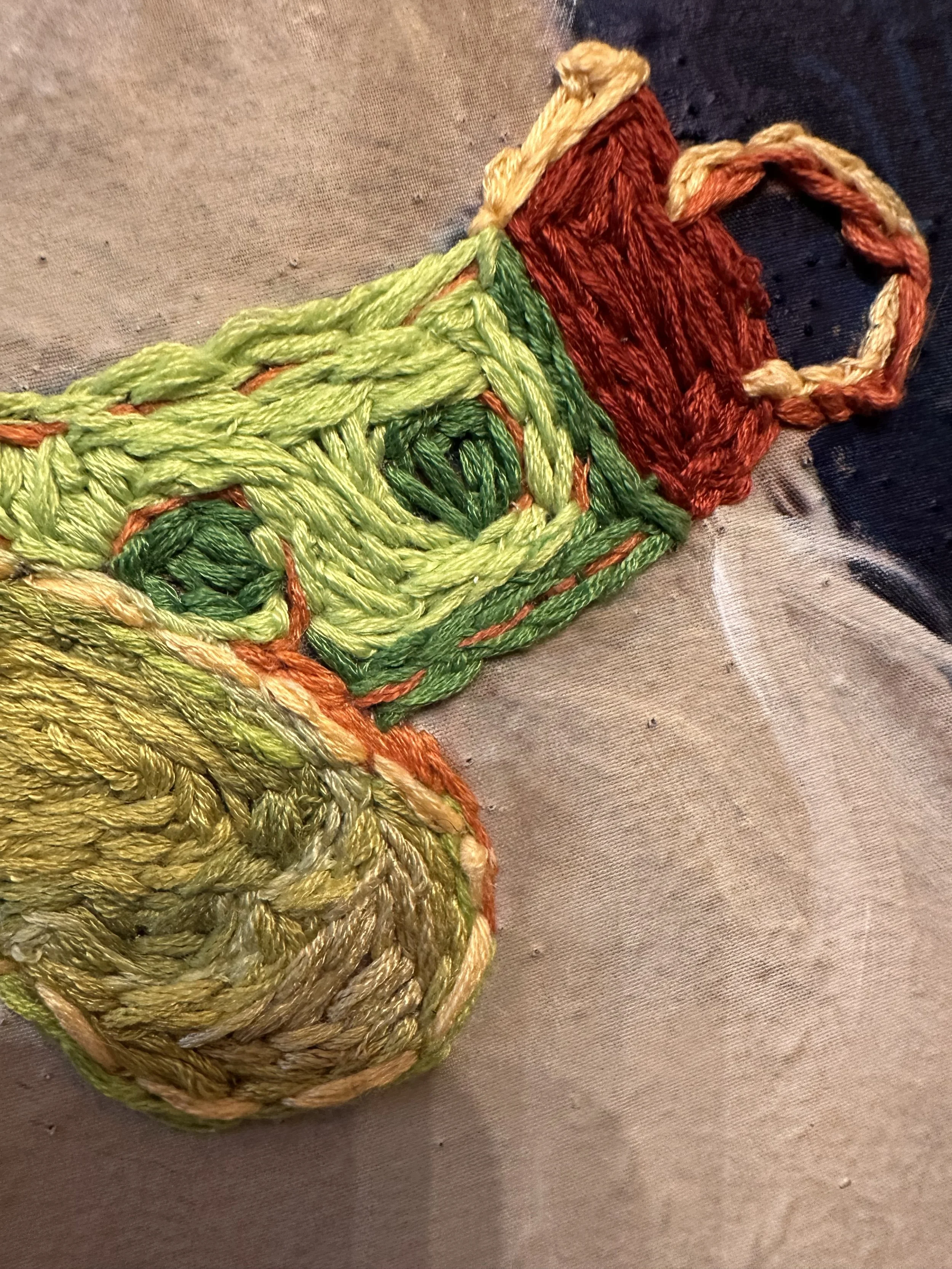 Close-up of a multicolored woven choker with green, yellow, red, and beige embroidery silk.