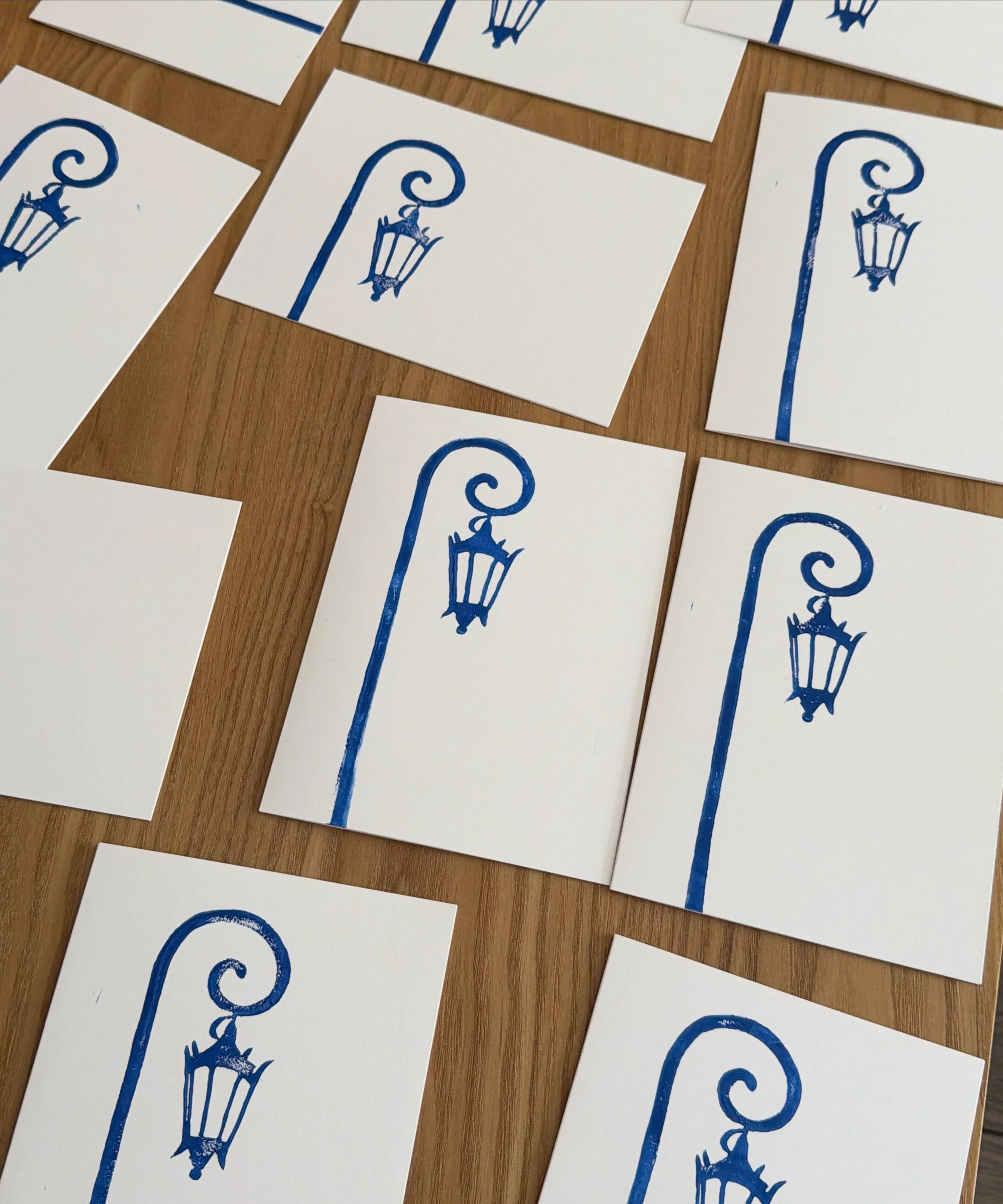 Cards with a blue illustration of a Wellesley college street lamp on a wooden surface.