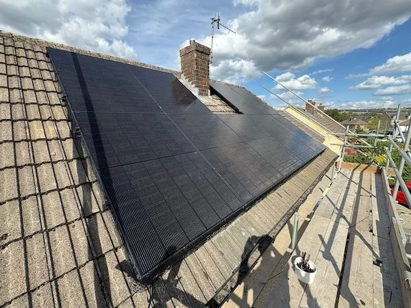 Solar panel array installed on a roof with chimney, overlooking Bradford and Keighley