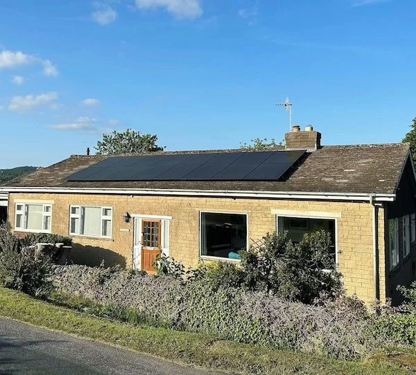 Stone bungalow with a large solar panel array installed on the roof, Harrogate