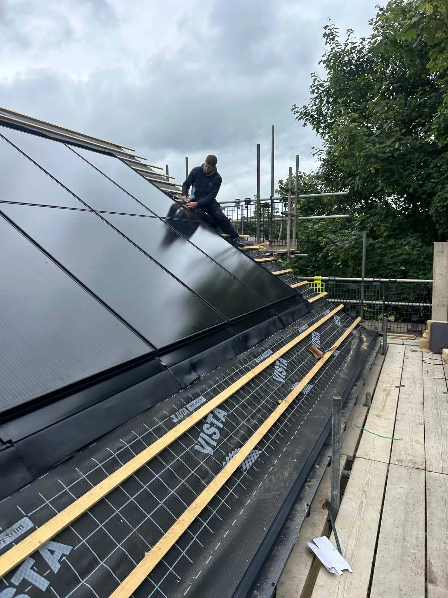 Solar installer working on roof of new build development