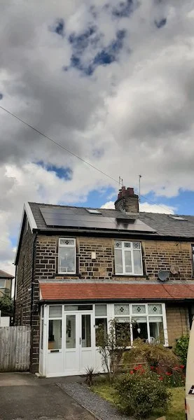 Solar panels installed on the roof of a stone-built semi-detached house, Bradford