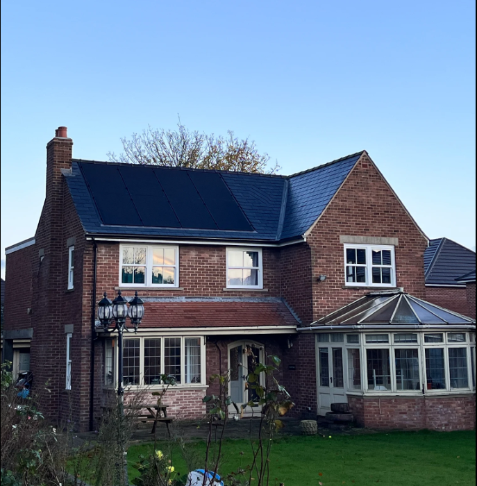 Detached family home with rooftop solar panels installed to reduce energy bills and improve energy efficiency.