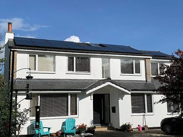 White-rendered detached house with solar panels installed on the roof, Harrogate