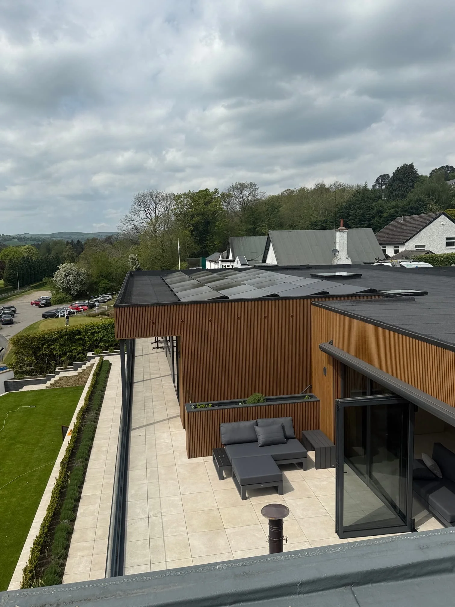 Residential property with solar panel installation and outdoor terrace overlooking surrounding countryside.