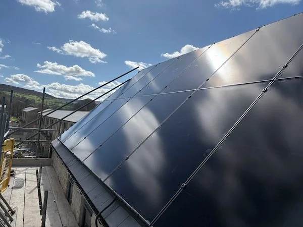 Aerial view of solar panels installed on a curved outbuilding roof, Keighley area