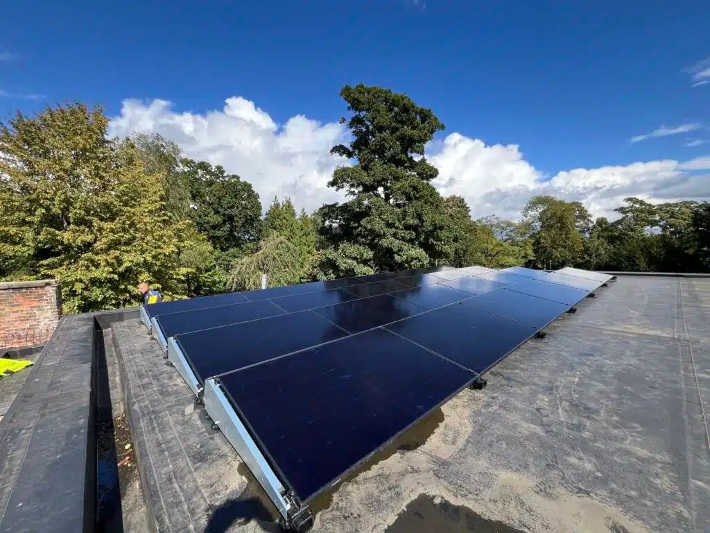 Completed 24-panel solar array installed on the flat roof of Burley Parish Library, generating renewable electricity for the community building.