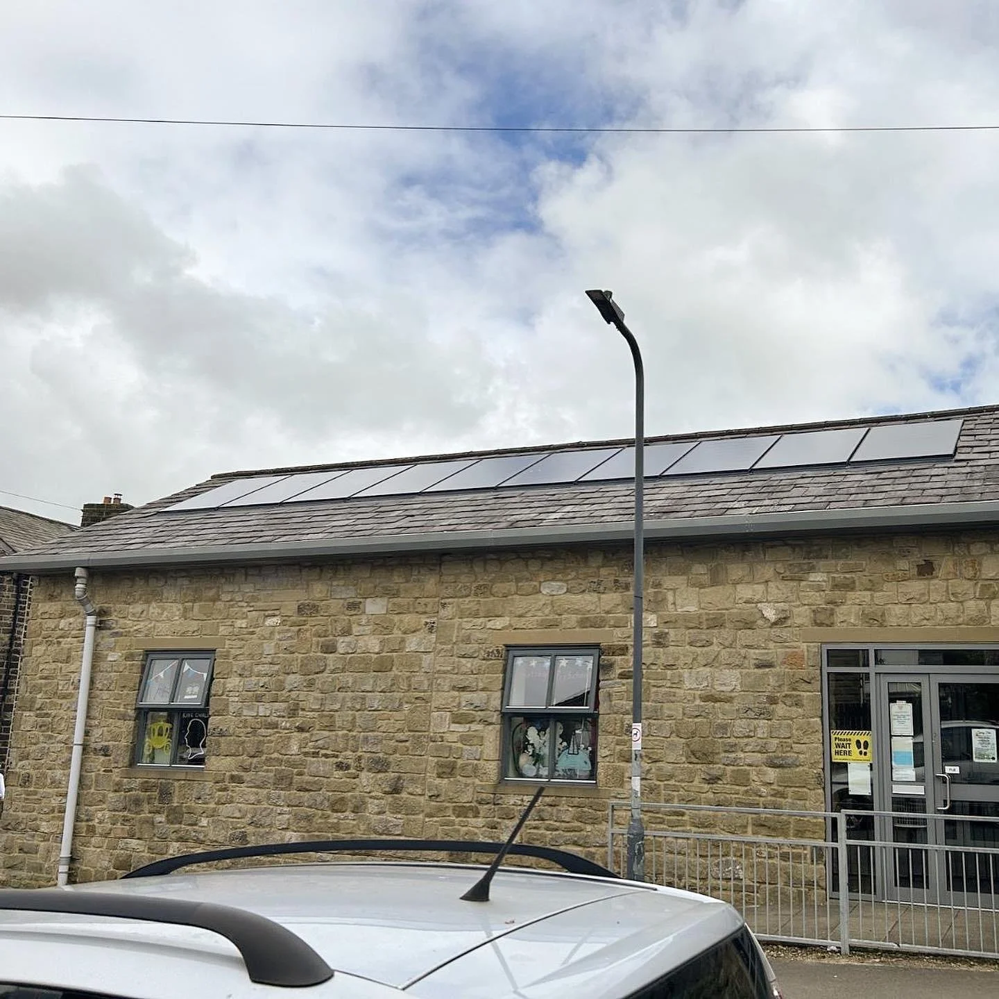 Stone-built property with rooftop solar panels installed to generate renewable energy and reduce electricity costs.