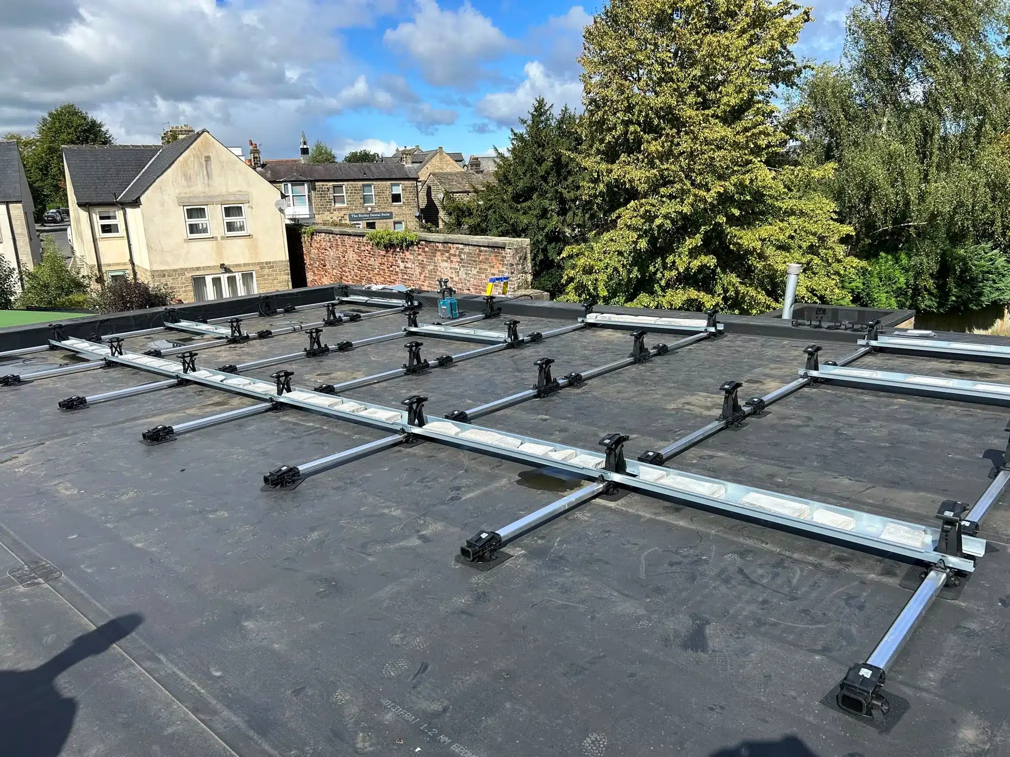 Solar panel mounting framework being installed on the flat roof of Burley Parish Library ahead of the solar panel installation