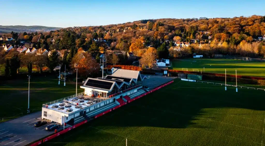 Aerial view of Ilkley RFU clubhouse with rooftop solar panels overlooking the rugby pitches, helping power the club with renewable energy.