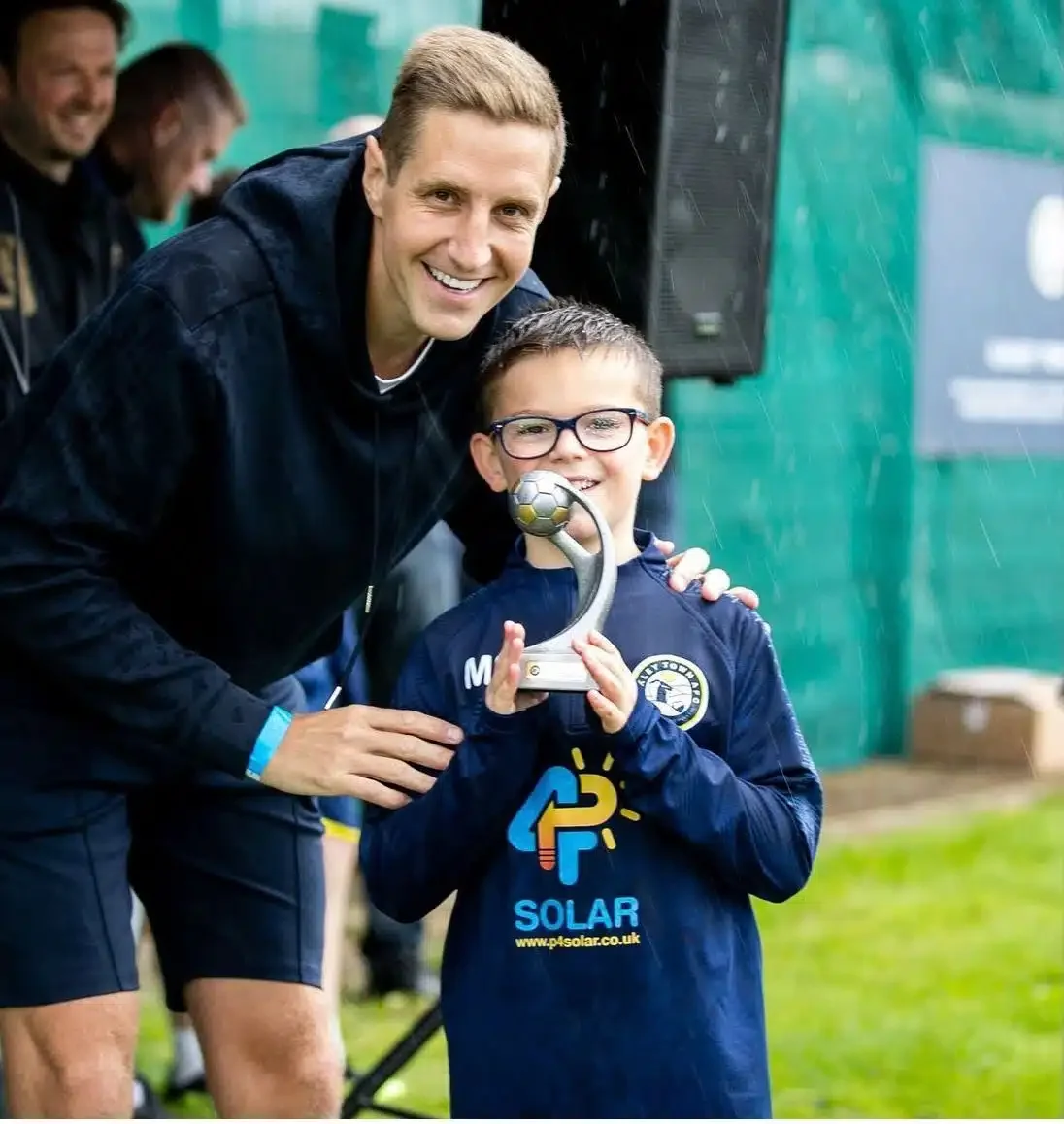 Young Ilkley Town AFC player wearing a P4 Solar sponsored training top while holding a trophy