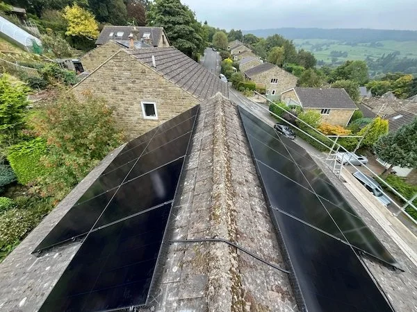 Aerial view along solar panels installed on a stone roof ridge overlooking the Harrogate countryside