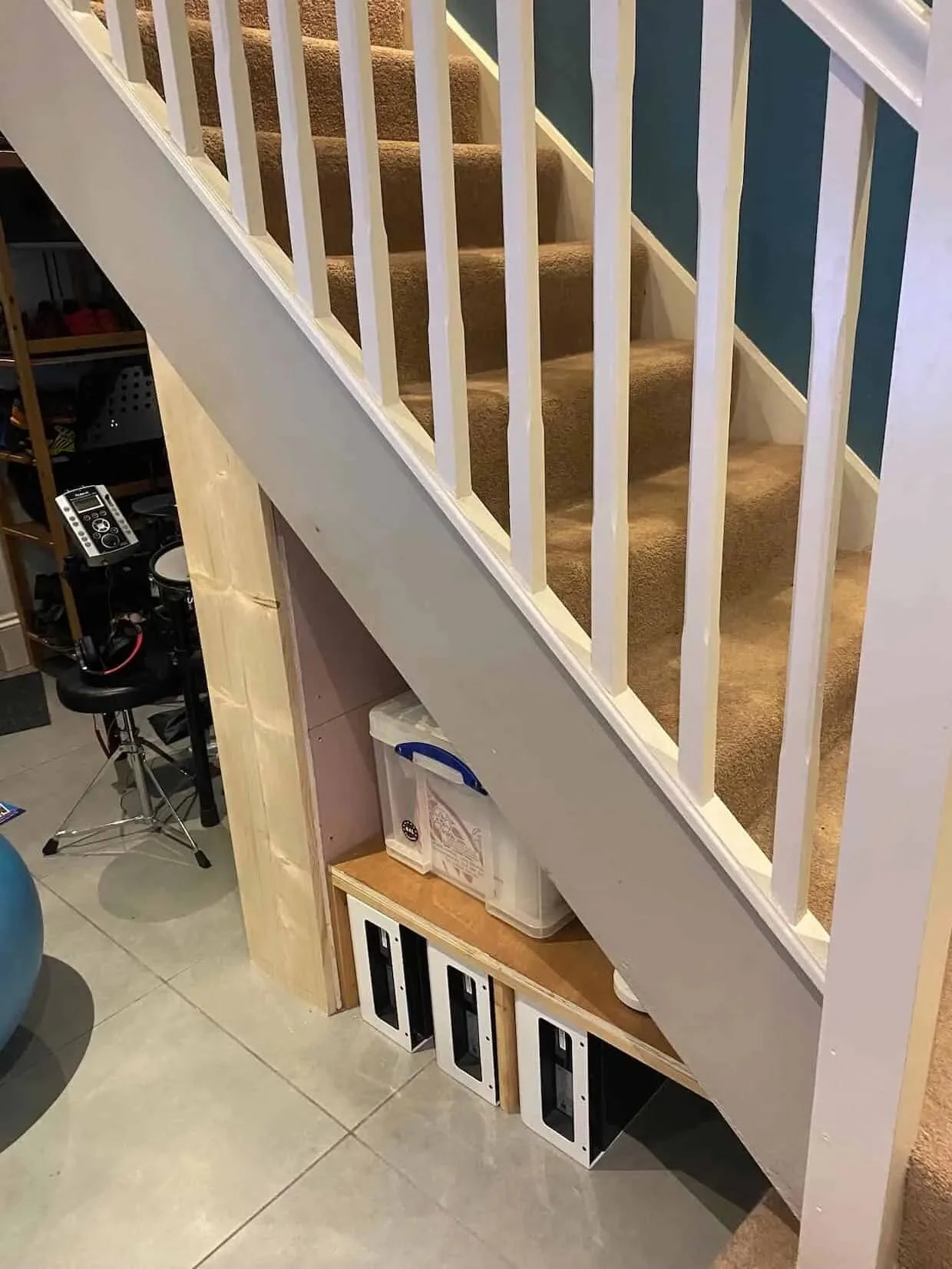 Battery storage modules neatly installed beneath a staircase in a residential property, creating a compact home energy storage solution that maximises space while supporting lower electricity costs and future solar integration.